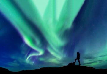 Homem admirando a Aurora Boreal na Finlândia