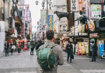 Homem com mochila nas costas, em avenida no Japão