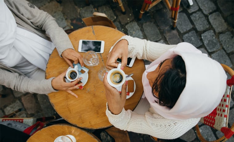 Jovens sentadas à mesa em um café na europa