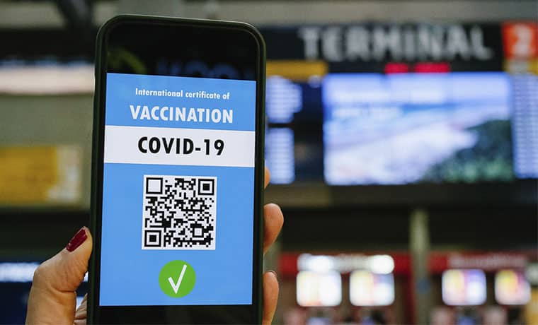 Celular com QR code de certificado internacional de vacina de Covid-19 em um aeroporto