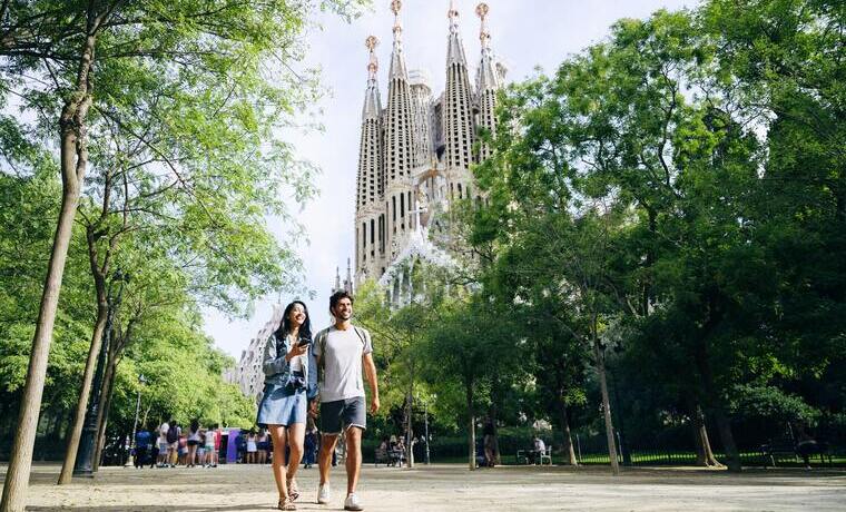 Casal passeando por Barcelona com Sagrada Família ao fundo