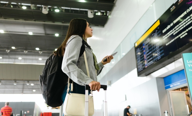 Mulher no aeroporto com a garantia de regresso antecipado seguro viagem