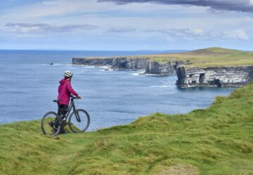Viajante andando de bicicleta com seguro viagem Irlanda