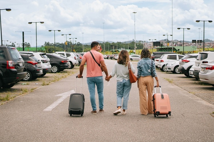 Família no aeroporto em direção ao estacionamento com malas. A cobertura do seguro viagem Brasília se estende às malas