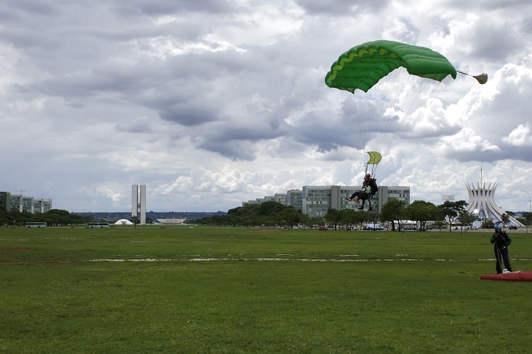 Pessoas pousando após salto de paraquedas 