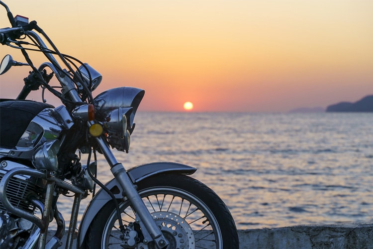 Vista de parte de uma motocicleta no pôr do sol