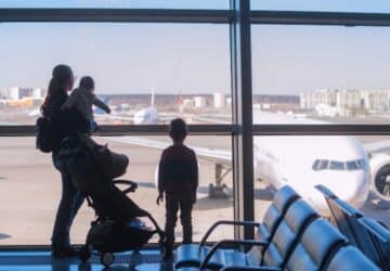 Família com crianças olhando para aviões no aeroporto