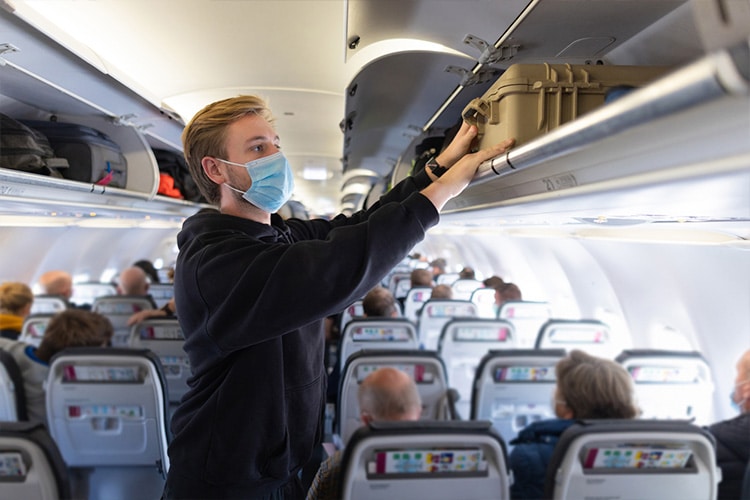 Turista em avião usando máscara cirúrgica