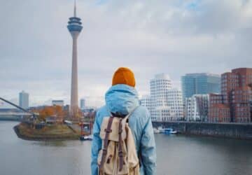 Mulher com mochila nas costas observando a paisagem urbana de Düsseldorf, na Alemanha