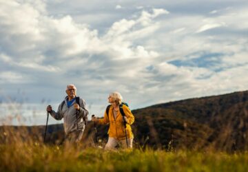 Homem e mulher fazendo trekking e curtindo uma viagem com seguro viagem para maiores de 70 anos