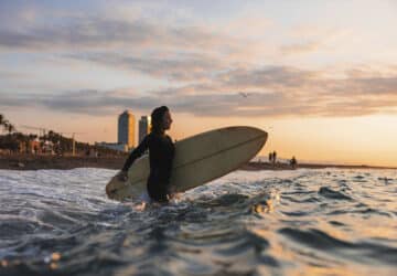 Mulher com prancha de surf no mar