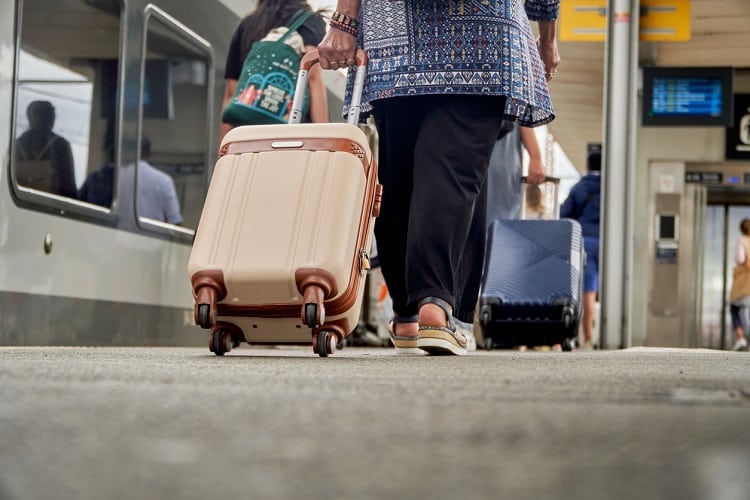 Mulher carregando bagagem em aeroporto, durante viagem.