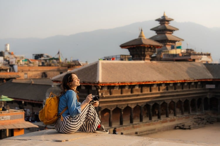Viajante com seguro da Welcome Assist sorrindo em templo do Nepal. 