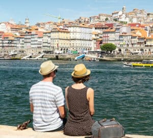 Turistas sentados à beira do Rio Douro no Porto, Portugal