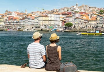 Turistas sentados à beira do Rio Douro no Porto, Portugal