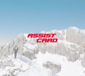 Alpinista caminhando nos alpes suíços. Em primeiro plano logo da assist card seguro viagem