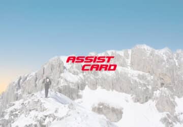Alpinista caminhando nos alpes suíços. Em primeiro plano logo da assist card seguro viagem