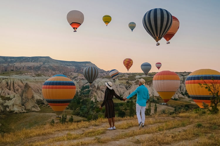 Casal apreciando os balões de ar na Capadócia, na Turquia.