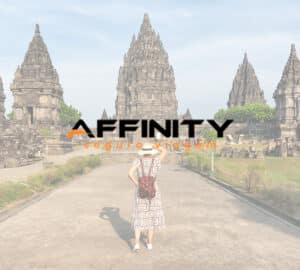 Turista aprecia a vista do templo de Prambanan, na Indonésia. Em primeiro plano, logo da Affinity Seguro Viagem