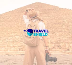 Mulher em frente a pirâmide do Egito. Em primeiro plano, logo Travel Shield