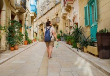 Turista caminhando pelas ruas de Malta, com seguro viagem.